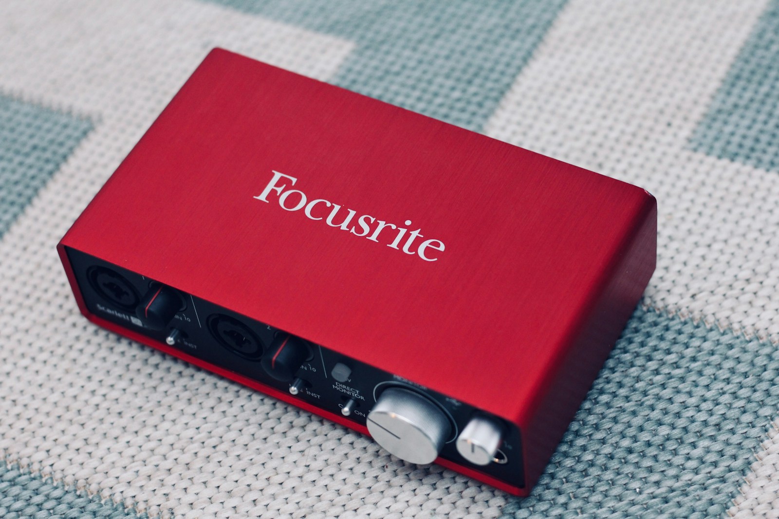 An audio interface on a desk with a microphone and headphones connected, ready for recording.