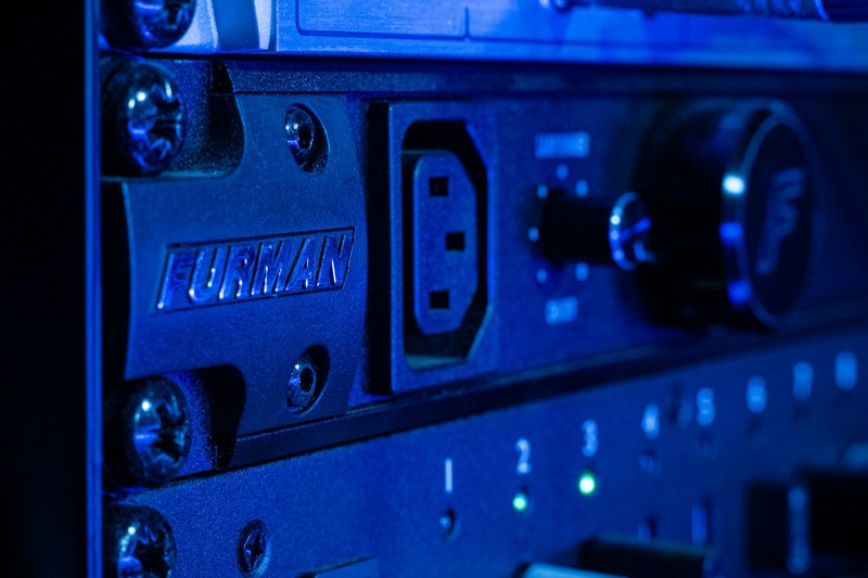 Black rack-mounted power conditioner with glowing front panel lights