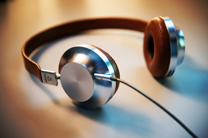 Five pairs of DJ headphones laid out on a dark wooden table showing Sennheiser, Pioneer, V-Moda, Audio-Technica, and Beyerdynamic models