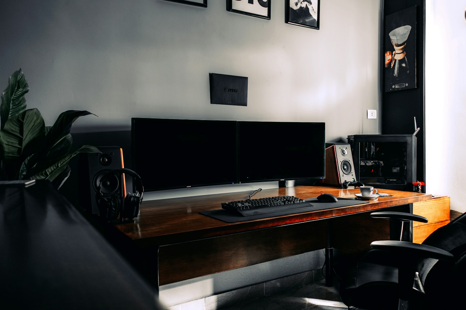 Budget studio monitors on a desk with a visible frequency response chart comparison showing uneven bass and treble