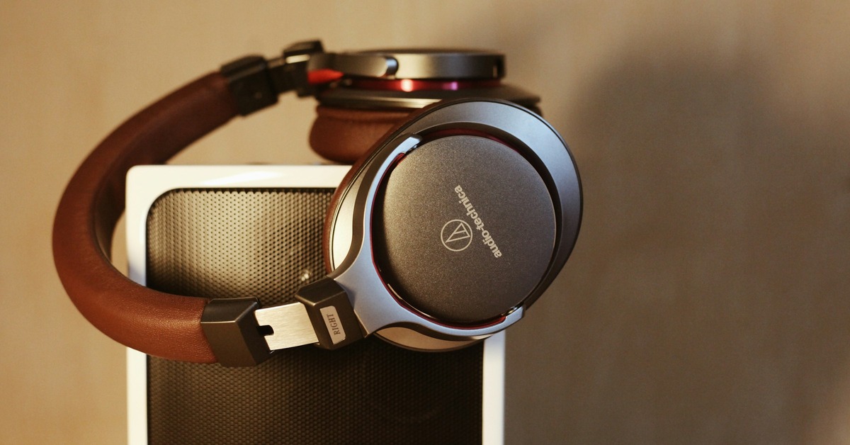 Comparison of a closed-back and an open-back studio headphone side by side on a desk