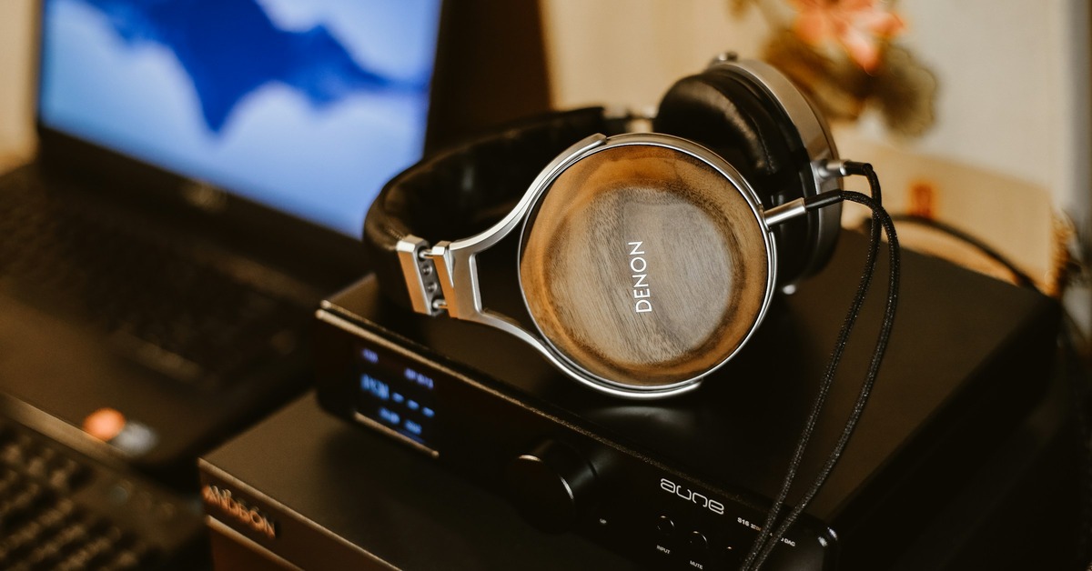 Denon DJ Prime 4 all-in-one DJ system with dual 7-inch touchscreens showing waveforms and library