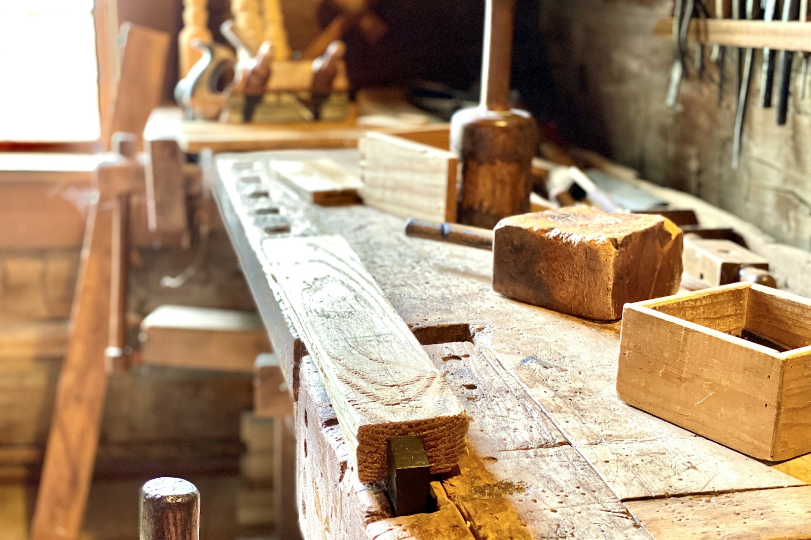 Detailed view of a guitar repair workbench with tools, strings, pickups, and small parts organized for servicing.