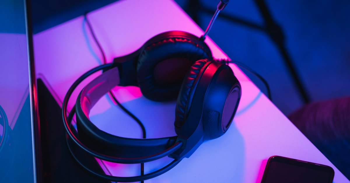A black DJ backpack open on a table revealing a controller, laptop, and headphones