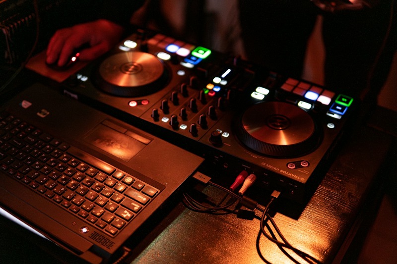 DJ controller connected to a laptop and mixer in a club setup