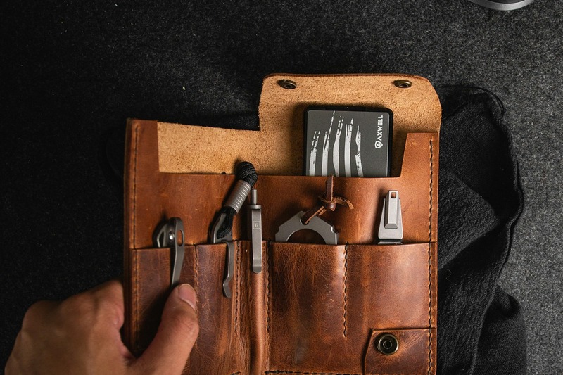 Small black pouch containing DJ emergency tools including adapters, cable ties, and clippers