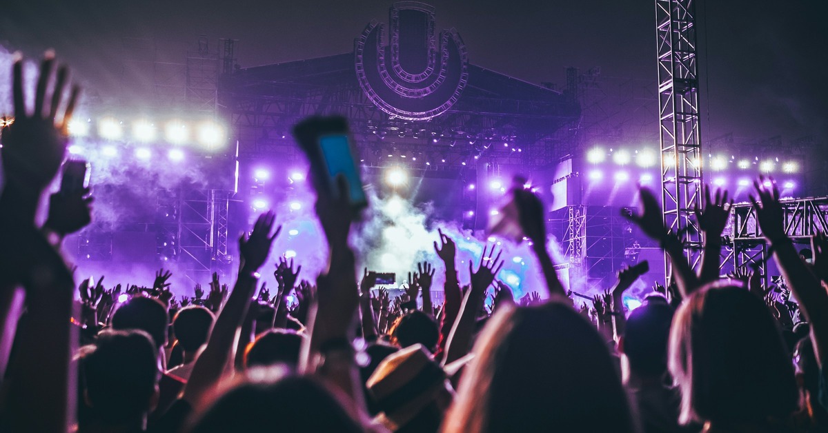 DJ performing at a music festival under bright stage lights