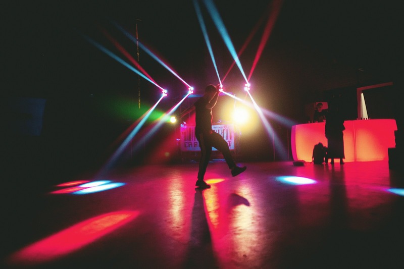 Moving head light projecting a beam effect onto a dance floor