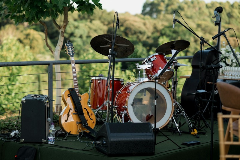 A DJ performing at an outdoor event using a small portable controller and laptop