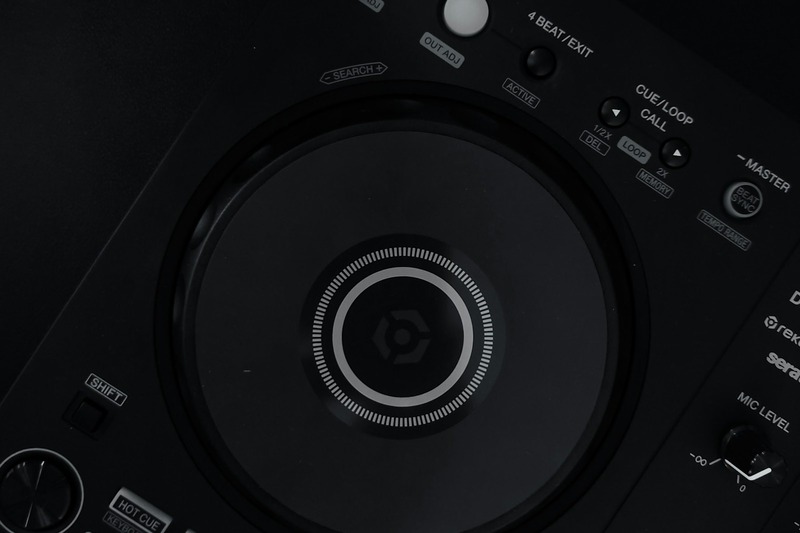 DJ using Pioneer DDJ-FLX10 during a club night with colorful lights