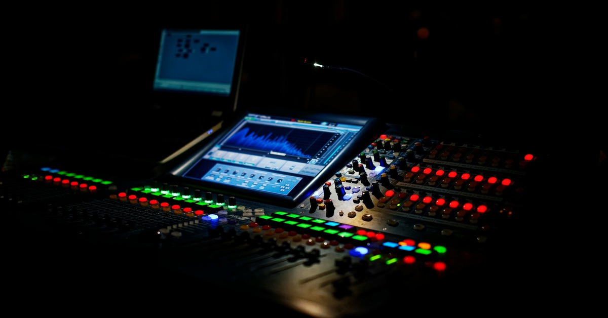 DJ wearing in-ear monitors while performing on stage in a dimly lit club