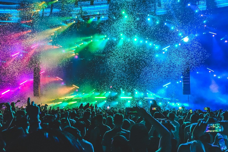 Nighttime music festival crowd with stage lights and performances