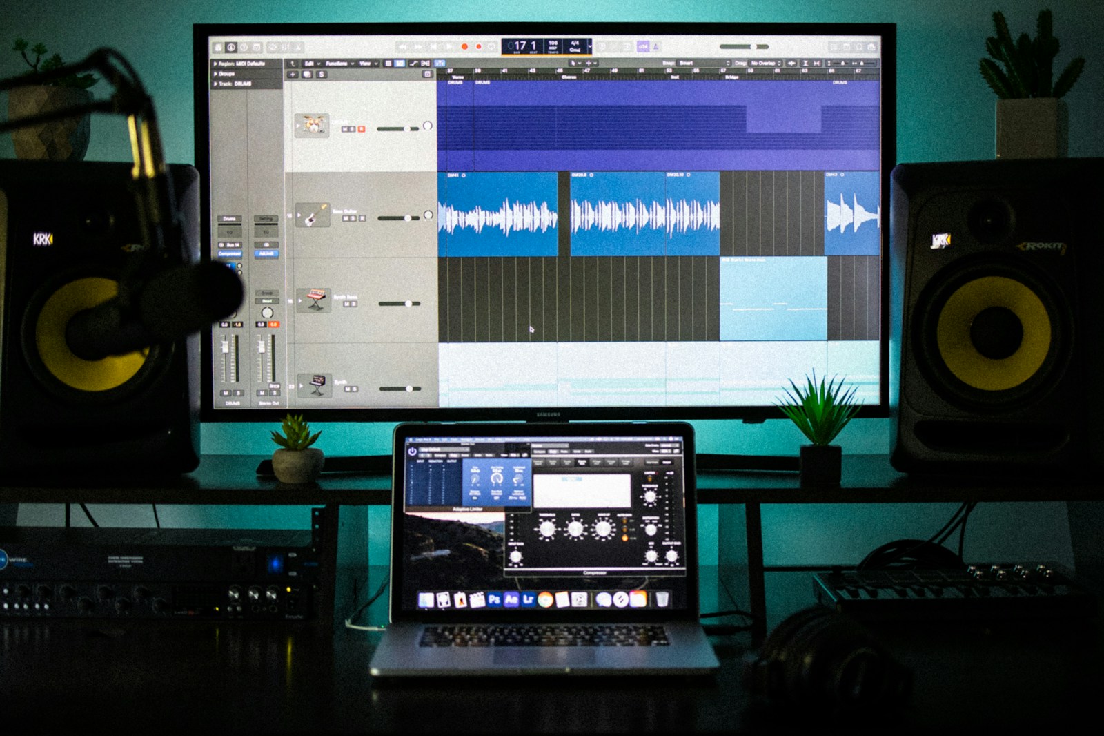 Home studio desk with studio monitor speakers, audio interface, and a laptop for music production
