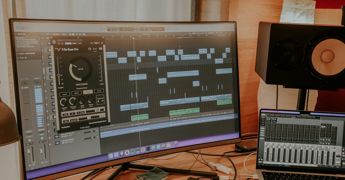 MacBook Pro connected to a desktop audio interface and studio monitors on a clean desk
