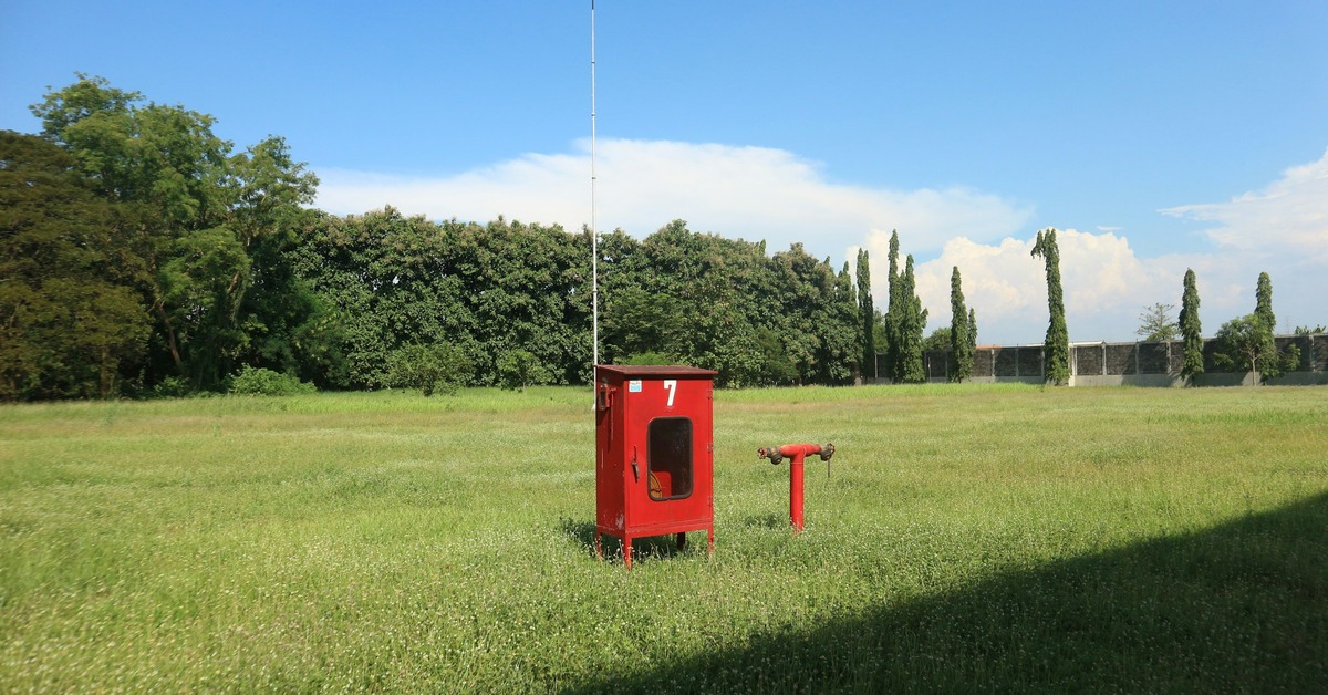Mobile DJ setting up a portable PA system for an outdoor wedding ceremony with speakers on stands
