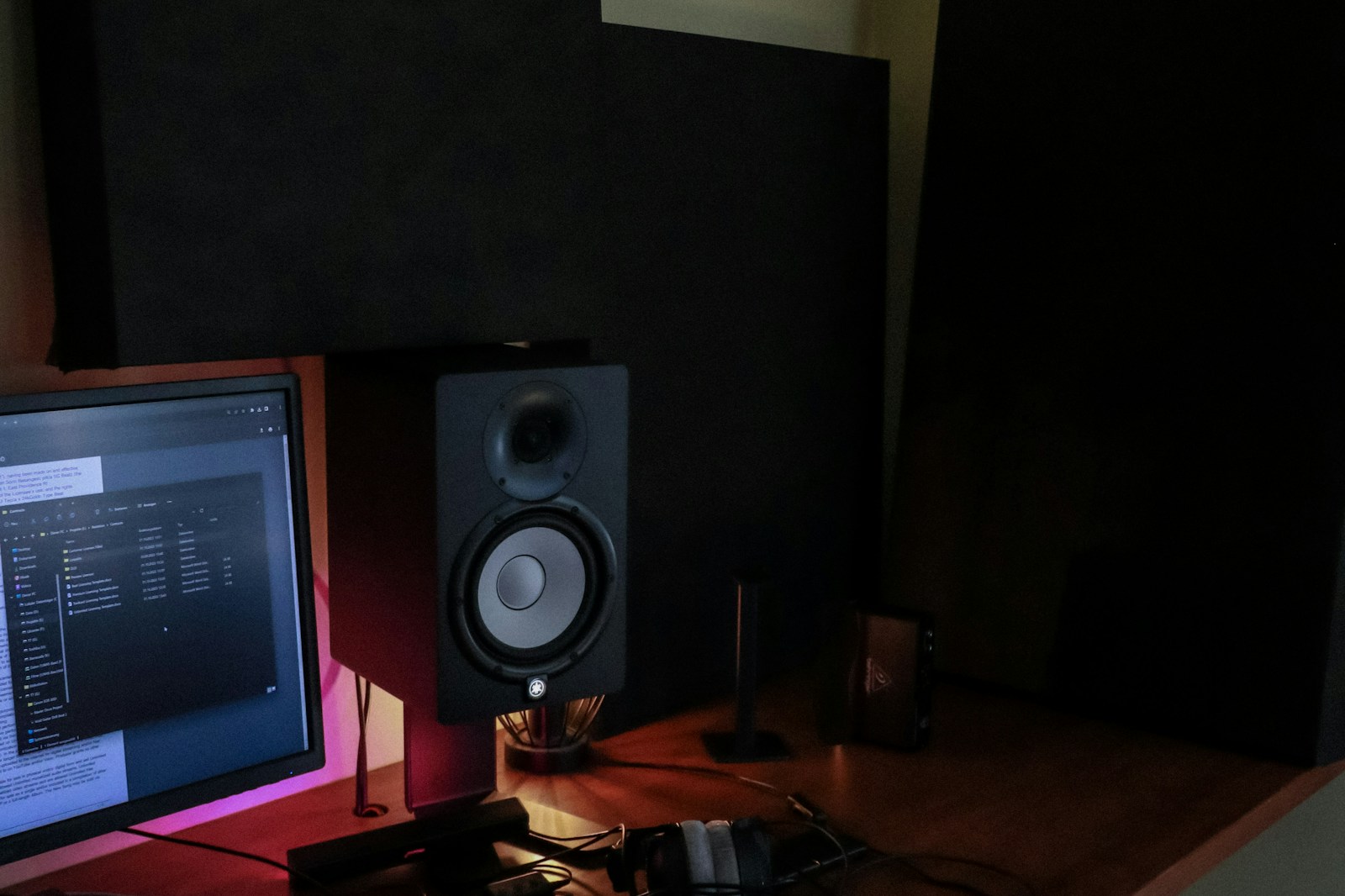 Nearfield monitor placement on a desk with acoustic panels on the wall and speaker stands improving listening accuracy.