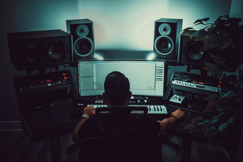 Open-back studio headphones placed on a headphone stand in a recording studio