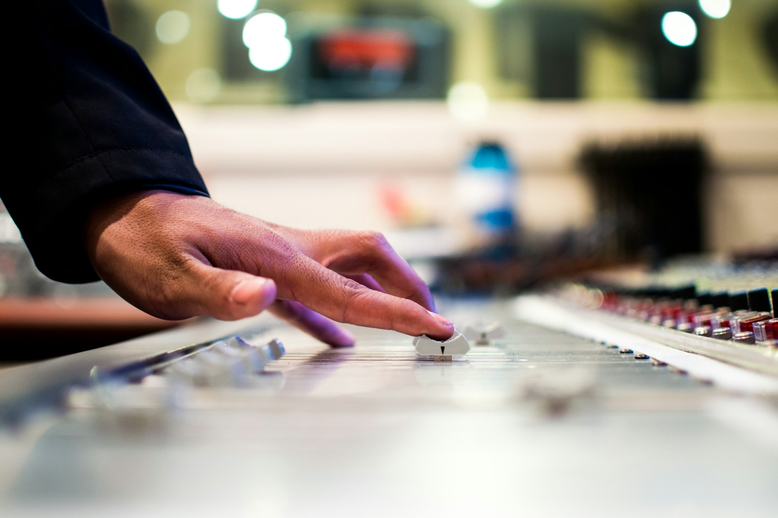 close-up of producer hands adjusting analog synthesizer patch cables