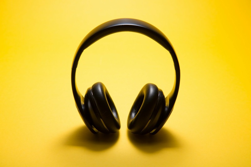 Studio monitors placed on stands at ear level with optimal listening position in a small room