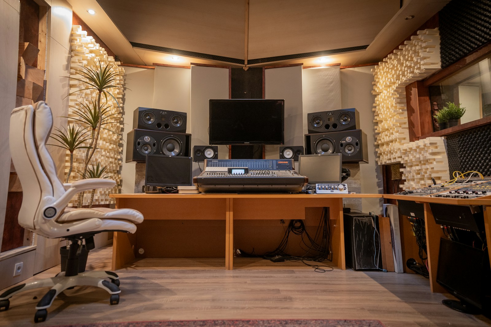 Team of music producers discussing a mix in a professional control room with studio monitors