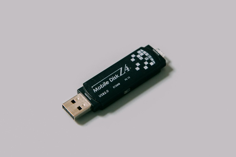 A high-speed USB drive next to a DJ mixer for music library export